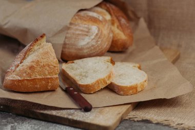 Taze ev yapımı taze ekmek, yumuşak odaklı. Fransız ekmeği. Leavenda ekmek. Mayasız ekmek. Ekmek dilimlemek için bir bıçak var..