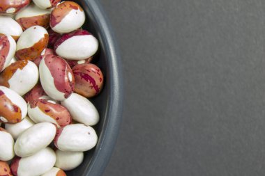 Gri arka planda siyah bir plaka içinde fasulye. B vitamini