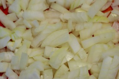 Kırmızı tahtada iyi doğranmış soğan yakın plan. Soğan arkaplanı