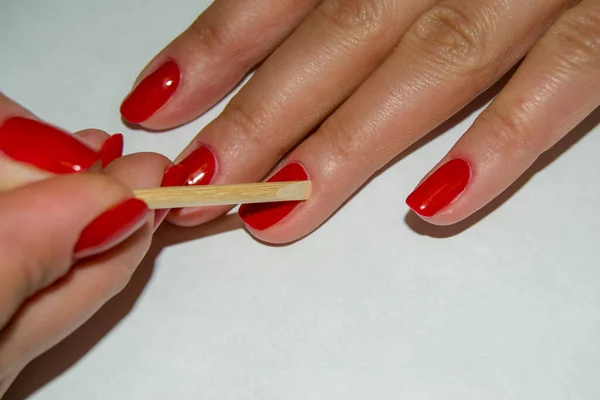 Tırnak derisini turuncu bir çubukla itme işlemi. Manikür. kırpma manikürü