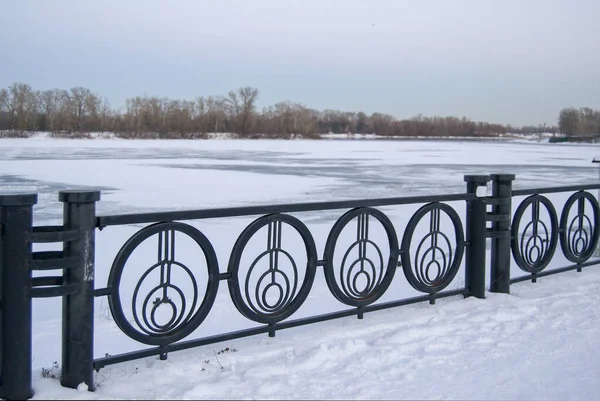 Karlı zeminde siyah çit var. Donmuş nehir. zobor çemberlerden oluşur