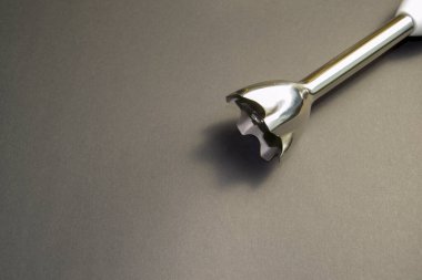 Bardakta yemek doğramak için bir araç. Gri arkaplanda el çırpıcı ögesi kapat