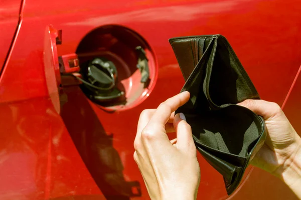 Kırmızı bir arabanın benzin deposunda boş bir cüzdan vardı. Cüzdanı kadınların elinde.
