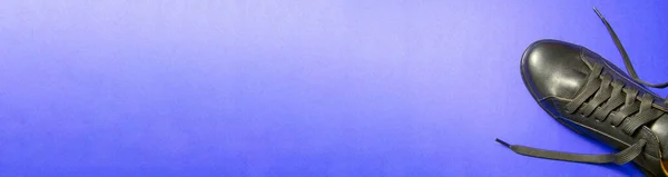 Sitenin afişi. Mavi arka planda siyah ayakkabılar. metin eklenecek yer