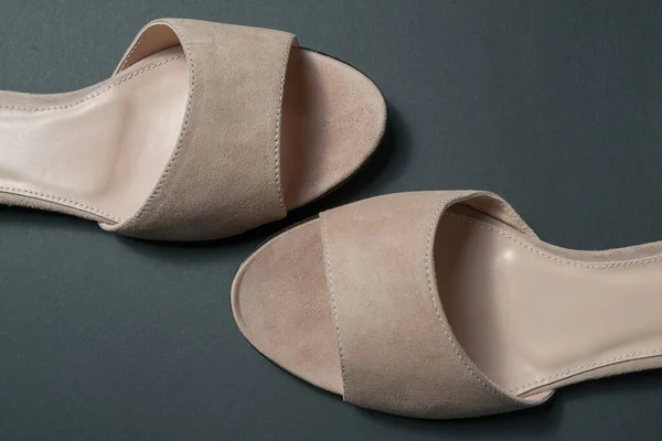 Siyah arka planda pudralı kadın ayakkabıları. Ayakkabılar üstten çıkarıldı. Ayakkabılar yatay olarak birbirine ters yatar..