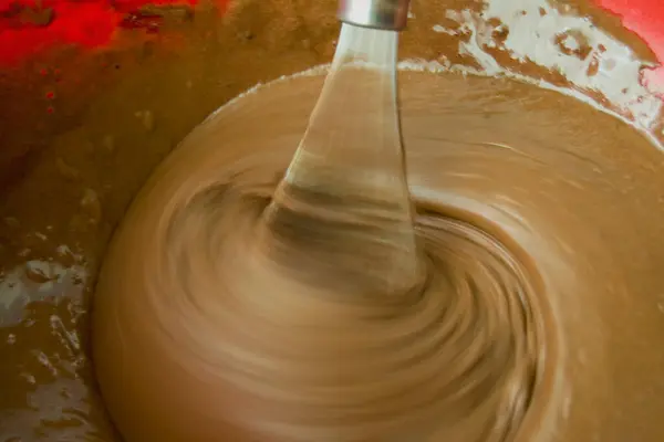 用搅拌机搅拌红饼奶油 厨房夹具上的糖水模糊了 奶油的表面上有气泡 — 图库照片