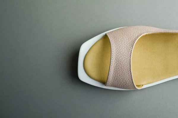 Gri arka planda bej renkli kadın ayakkabıları. Ayakkabılar üstten çıkarıldı. ayakkabılar yatay