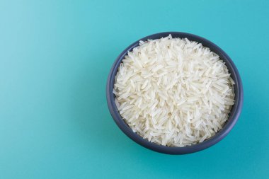 Mavi arka planda siyah bir tabakta basmati pilavı.