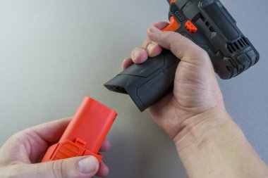 Toplayıcının tornavidaya olan bağlantısı. Adam elinde matkap tutuyor. Delik açmak için aygıt