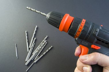 Adamın eli tornavida tutuyor. Makine delikleri ve vida için alet. sondaj yakın çekim