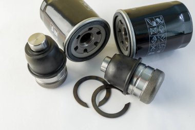 Beyaz arka planda top eklem ve yağ filtresi. Arabanın yeni yedek parçaları. Otomobil süspansiyonu ve motoru ögeleri