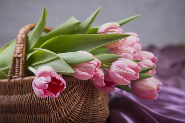 Wicker basket with bouquet of pink tulips — Stock Photo, Image