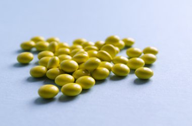 Sarı yuvarlak bir açık mavi renkli hapları