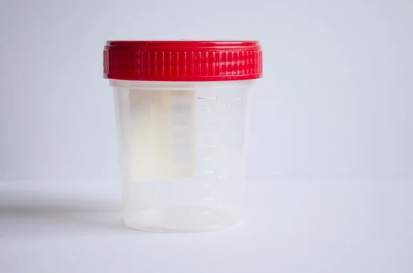 Empty container with red cap for collecting material for tests — Stock Photo, Image