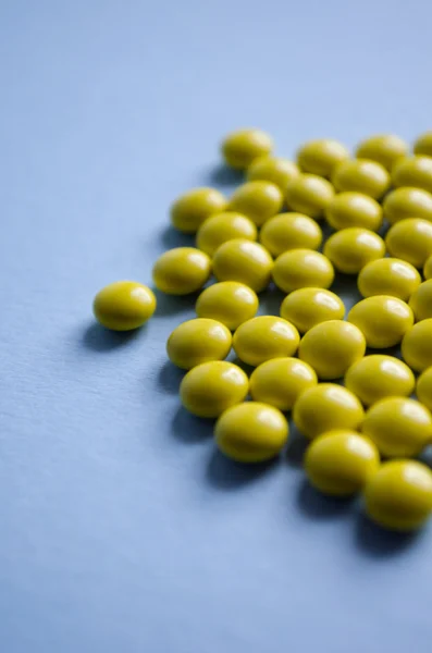 Yellow round pills on a blue background — Stock Photo, Image