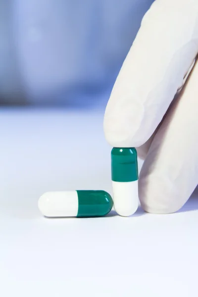 Yakın çekim elinde iki yeşil ve beyaz holding tıbbi lastik eldiven — Stok fotoğraf