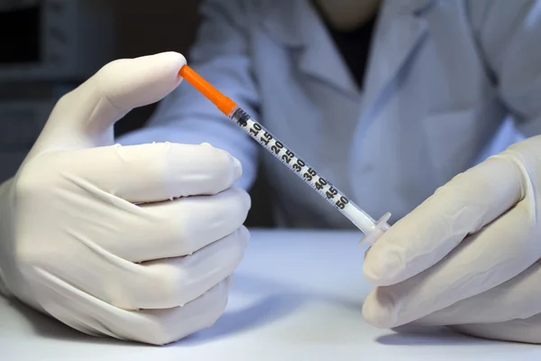 Ręce w medycznych gumowe rękawice trzyma jedna strzykawka insuliny — Zdjęcie stockowe