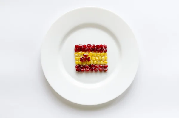 Creative flag of Spain from corn and pomegranate on white round — Stock Photo, Image
