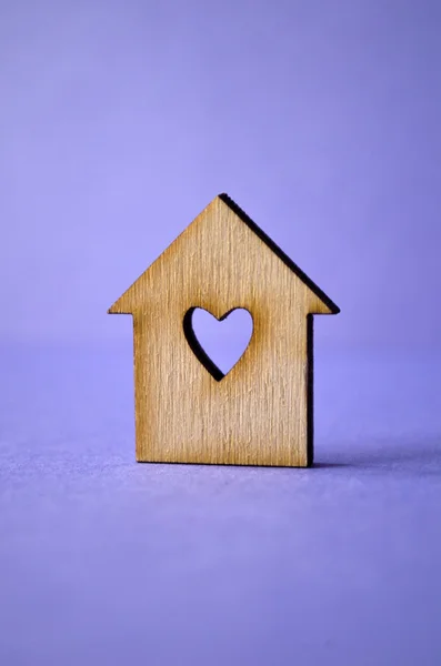 Wooden house with hole in the form of heart close-up on purple b — Stock Photo, Image