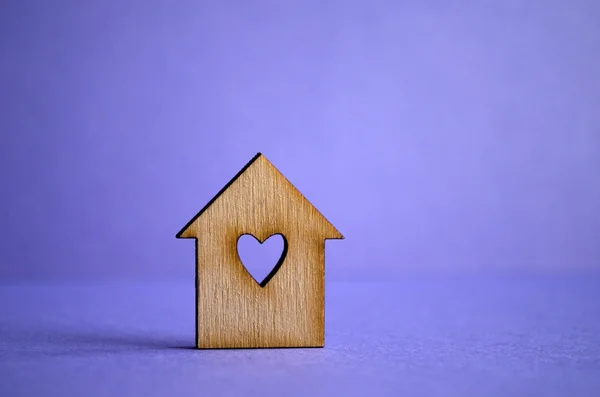 Wooden house with a hole in the form of heart on a purple backgr — Stock Photo, Image
