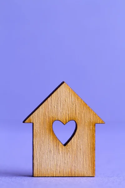 Casa de madeira com buraco na forma de coração no fundo roxo — Fotografia de Stock