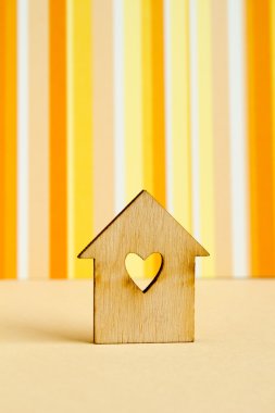 Turuncu çizgili ba üzerinde kalp şeklinde deliği olan ahşap ev