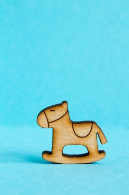 Çocuk sallanan at mavi zemin üzerine ahşap simgesi
