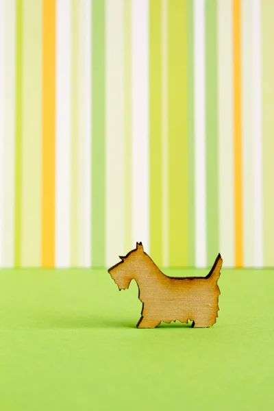 Деревянная икона собаки на зеленом полосатом фоне — стоковое фото