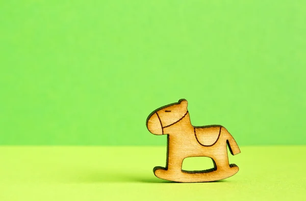 Icona in legno di cavallo a dondolo per bambini su sfondo verde — Foto Stock