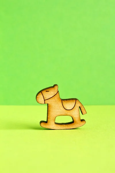 Icona in legno di cavallo a dondolo per bambini su sfondo verde — Foto Stock