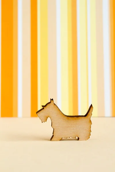 Деревянная икона собаки на оранжевом полосатом фоне — стоковое фото