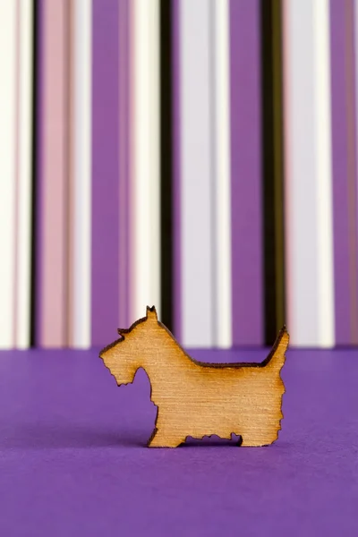 Wooden icon of dog on purple striped background — Stock Photo, Image