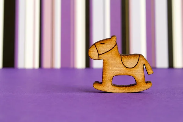 Icona in legno di cavallo a dondolo per bambini su dorso a strisce viola — Foto Stock