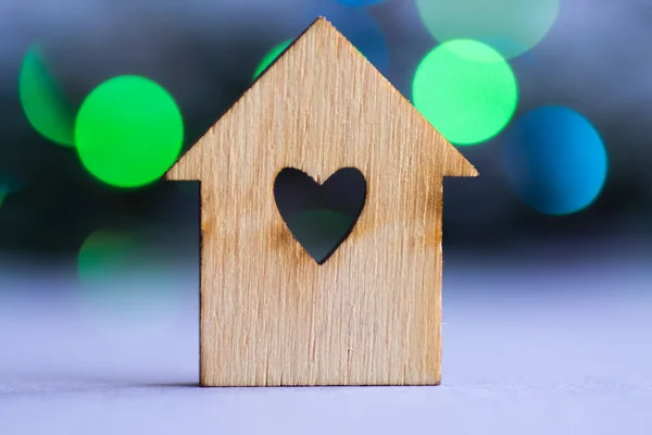 Casa in legno con foro a forma di cuore su sfondo bokeh — Foto Stock