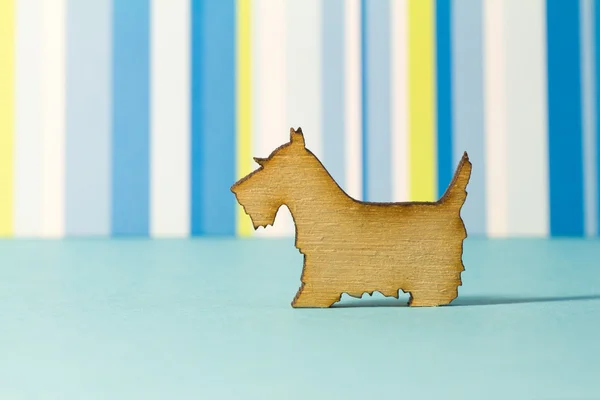 Drewniane ikony psa na niebieskim tle pasiasty — Zdjęcie stockowe