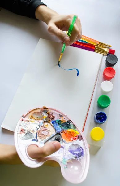 Levá ruka kreslí štětec s modrou barvou na papíře v albu s sev — Stock fotografie