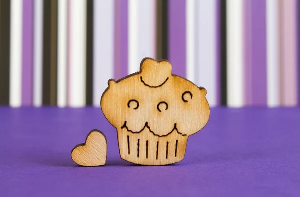 Wooden icon of cake with little heart on purple striped backgrou — Stock Photo, Image