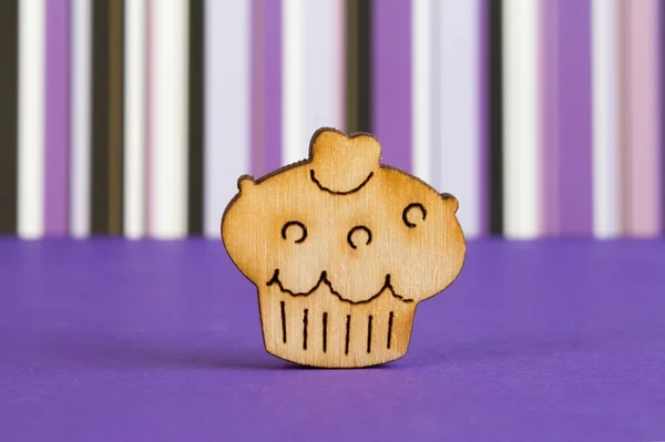 Wooden icon of cake on purple striped background — Stock Photo, Image