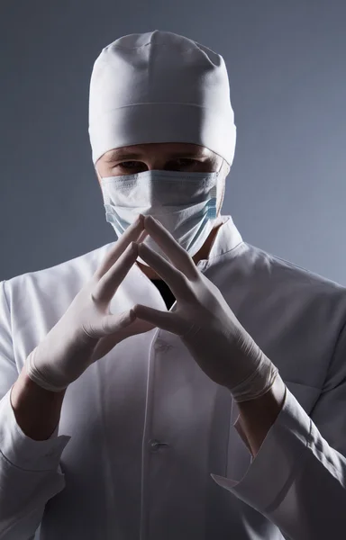 Mężczyzna lekarz w WPR i maska zakładać gumowe rękawice medyczne w contra — Zdjęcie stockowe