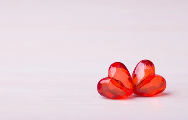 Dvě plastové červenou tváří srdce na světlé pozadí — Stock fotografie