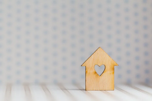 Casa in legno con foro a forma di cuore su luce macchiato bac — Foto Stock