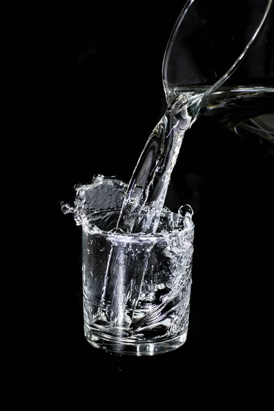 Glass with water on a black background. Photo taken with selective focus and noise effect