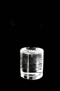 Siyah arka planda dolu bir bardak su. Fotoğraf seçici odak ve gürültü efektiyle çekildi