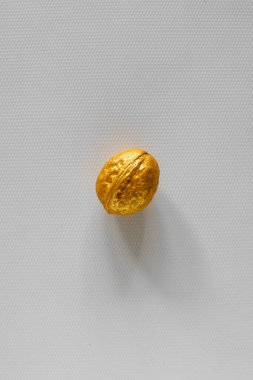 Beyaz arka planda altın rengi ceviz. Fotoğraf seçici odak ve gürültü efektiyle çekildi