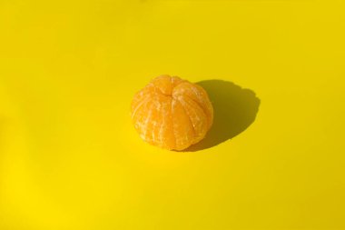 Sarı arka planda soyulmuş mandalina. izole et
