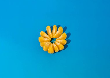 Mavi arka planda soyulmuş mandalina. Fotoğraf seçici odak ve gürültü efektiyle çekildi