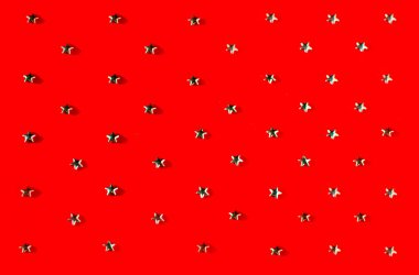 Kırmızı arka planda gümüş yıldızlar. Fotoğraf seçici odak ve gürültü efektiyle çekildi