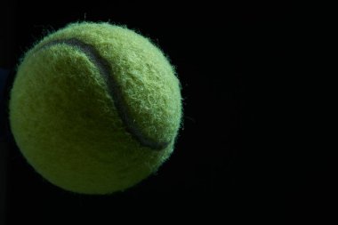 Siyah arkaplanda yeşil tenis topu