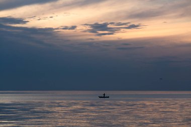 Gölde ve denizde bulutlu bir manzara Kanolar ve teknelerle