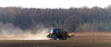 Traktör gündüz sahada çalışıyor.